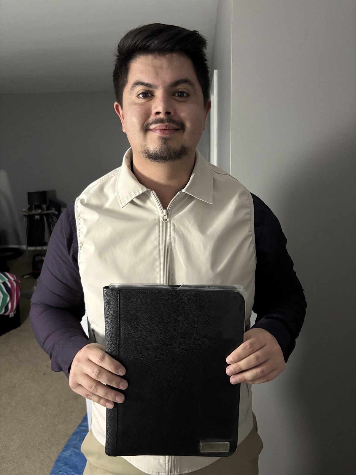 Alex holding a portfolio binder